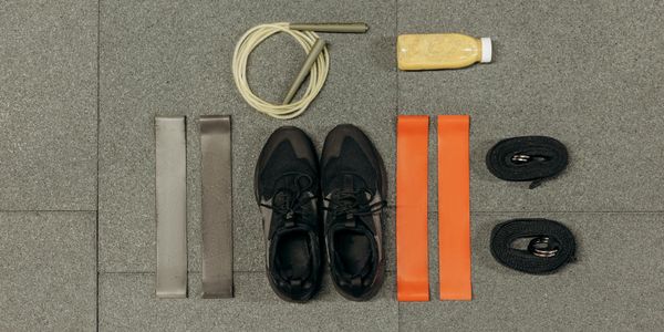 A pair of training shoes placed neatly next to a water bottle.